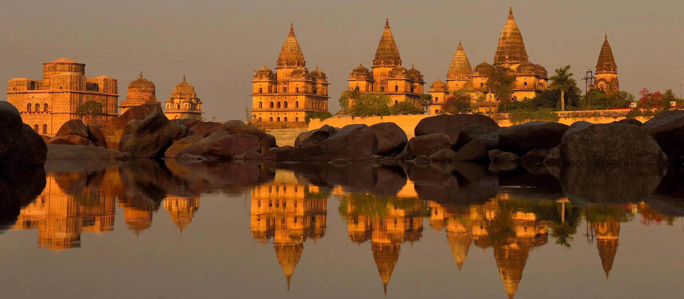 Orchha’s royal cenotaphs in golden evening light, mirrored in the still Betwa River